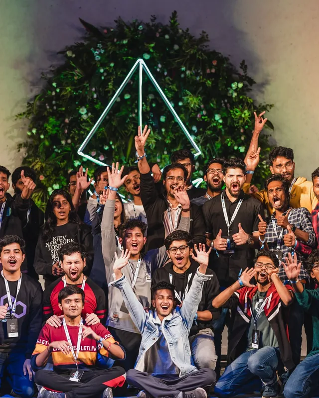 A large group of builders cheering in front of the ETHIndia 2022 stage