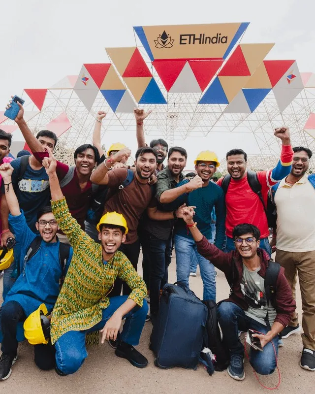 A group of builders cheering at the ETHIndia 2023 entrance arch